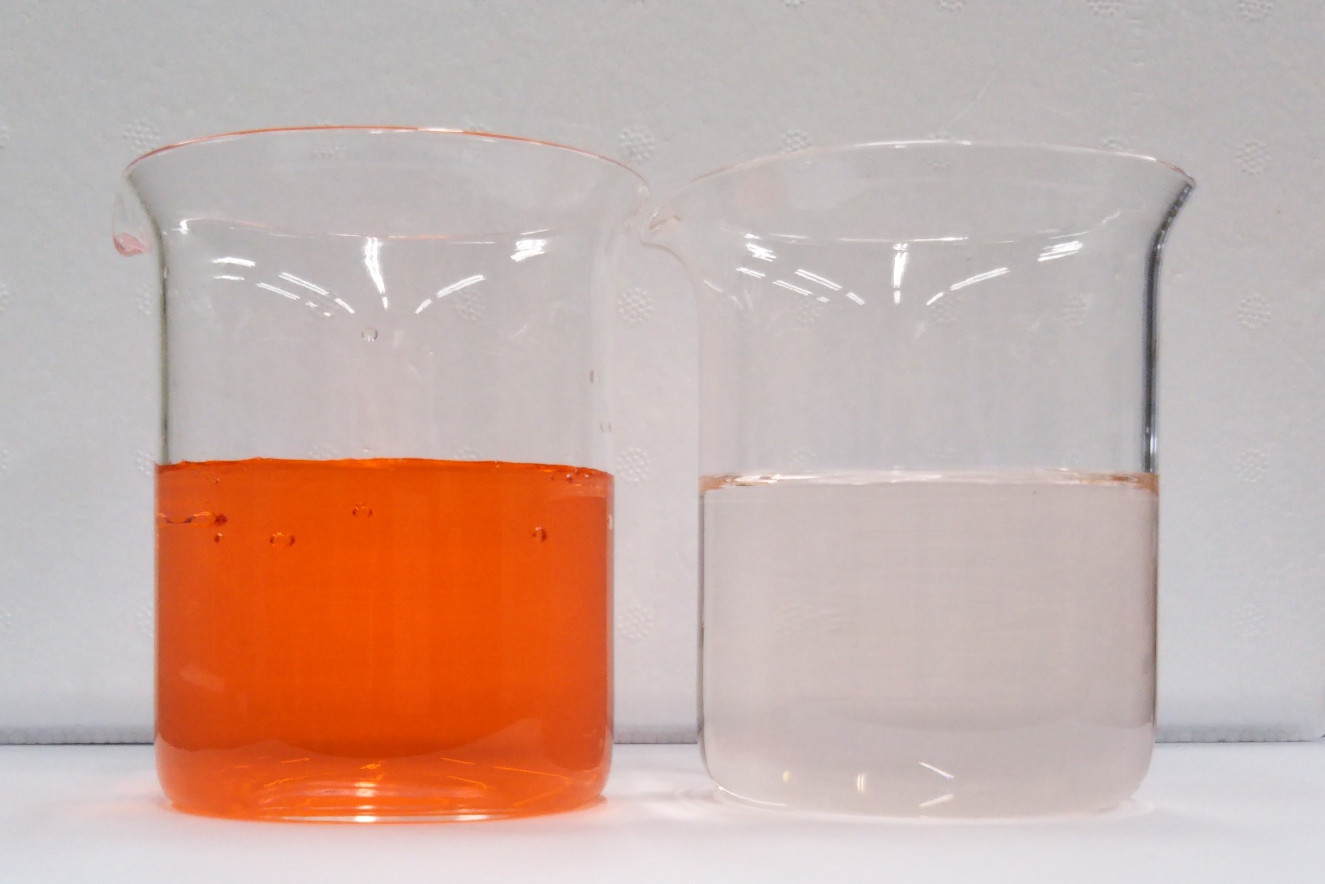 赤インクの水溶液（左）を水で水をキレイにする水の浄化技術で処理した水（右）の写真
