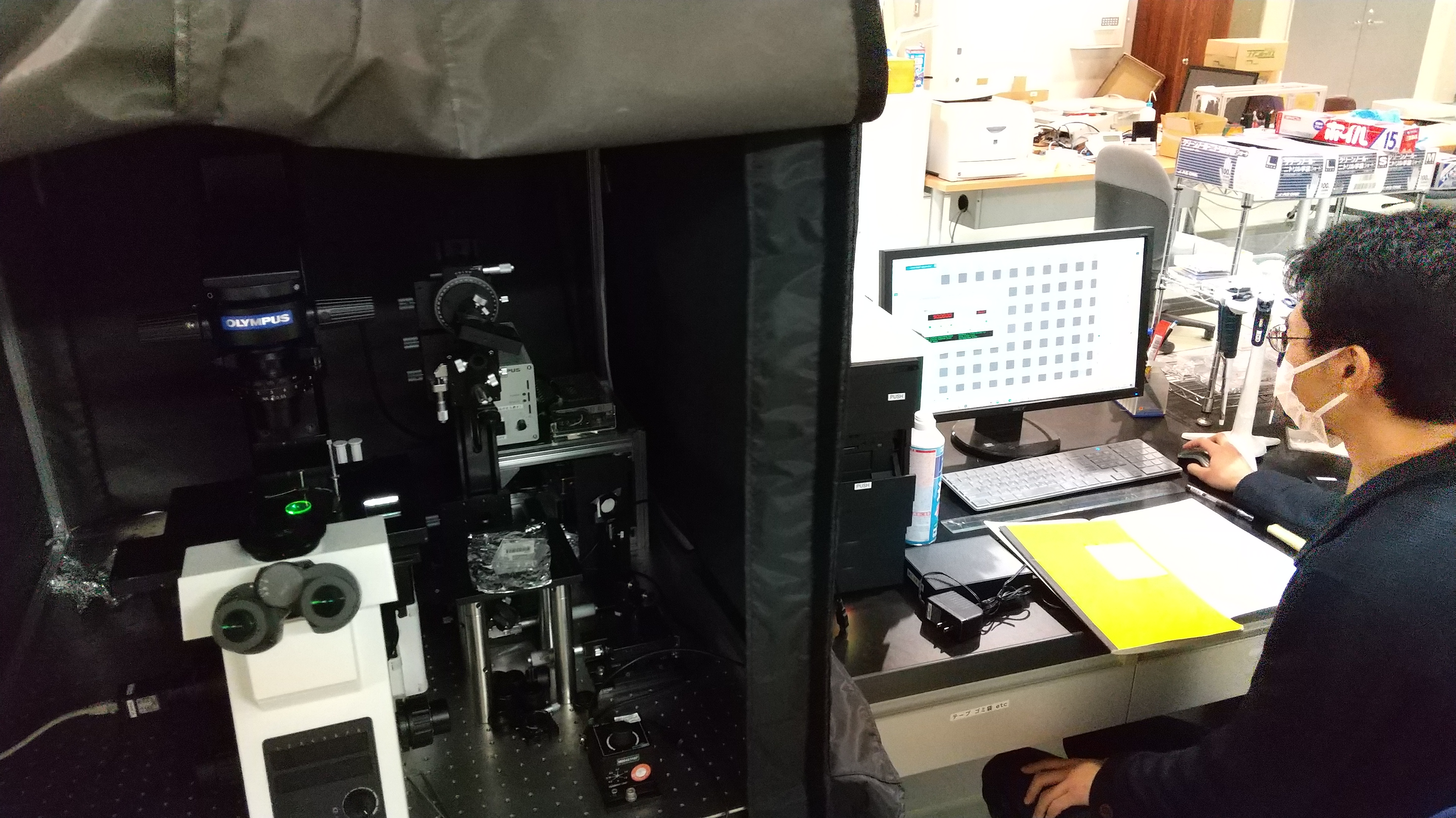蛍光偏光測定の実験を行っている様子。自作の光学系や温度制御システムを顕微鏡に組み込んでオリジナルの装置を作り、温度や粘度などの可視化を行ってます。