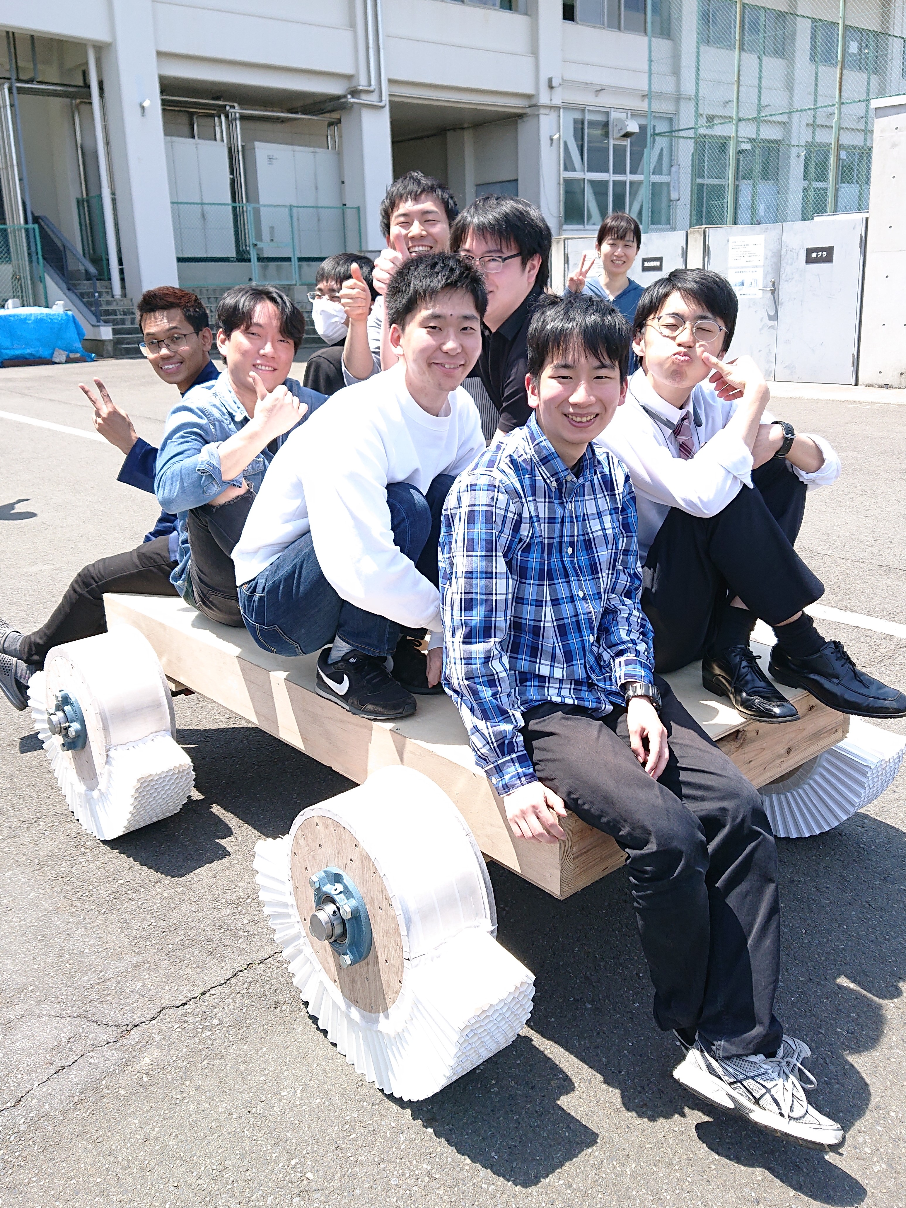 明治大学生田キャンパス(神奈川県川崎市)での折紙タイヤの実験風景です。折紙タイヤを取り付けた台車に学生が一人ずつ乗り、1トン載っても潰れない折紙タイヤができました。