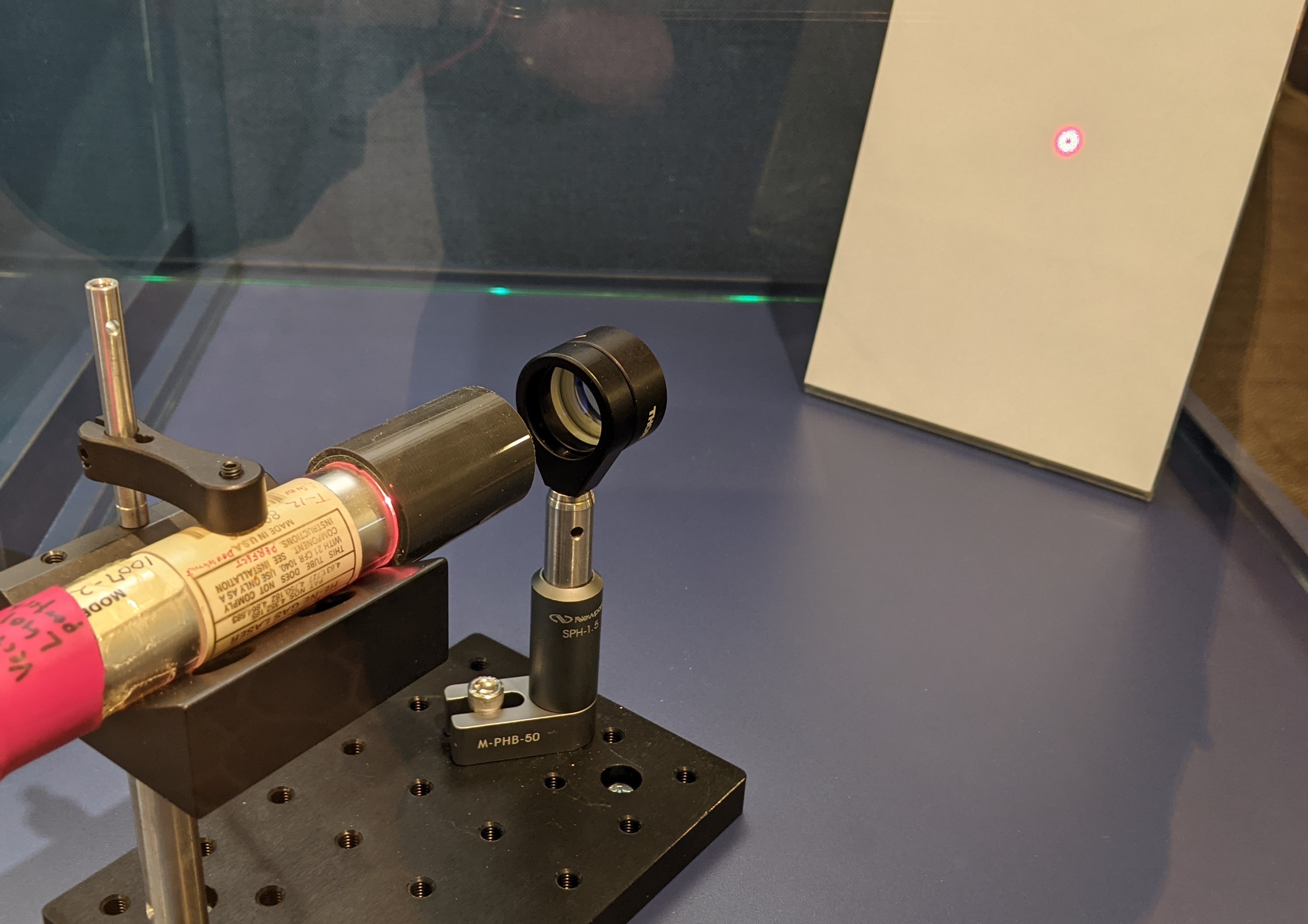 我々の研究室で開発した、世界で唯一のドーナツビームを発生させるHe-Neレーザーです。赤色のレーザー光を出すHe-Neレーザーに対して、独自の技術に基づいて改造を行いました。出力ビームは中心に穴の空いたドーナツ状の形をしていることがわかると思います。