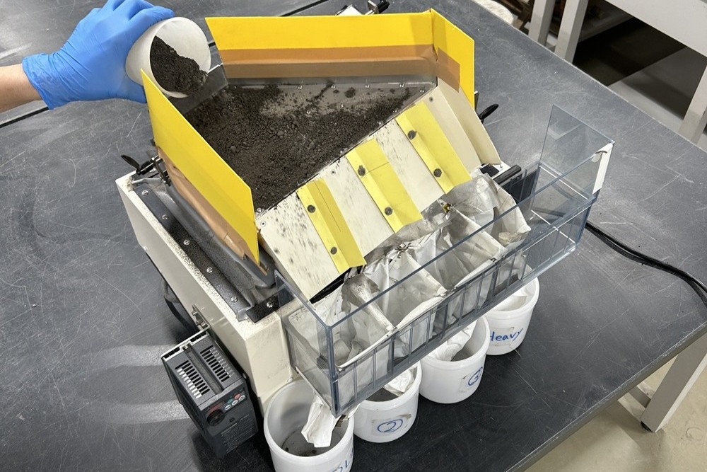 研究で使用している比重差選別装置です。この装置は、振動数・空気量・スロープの傾きなどを自由に調整することができます。この装置を使って焼却灰を密度の軽いものから重たいものに分別し、分別した焼却灰を砂の代わりとして使用する研究を行っています。