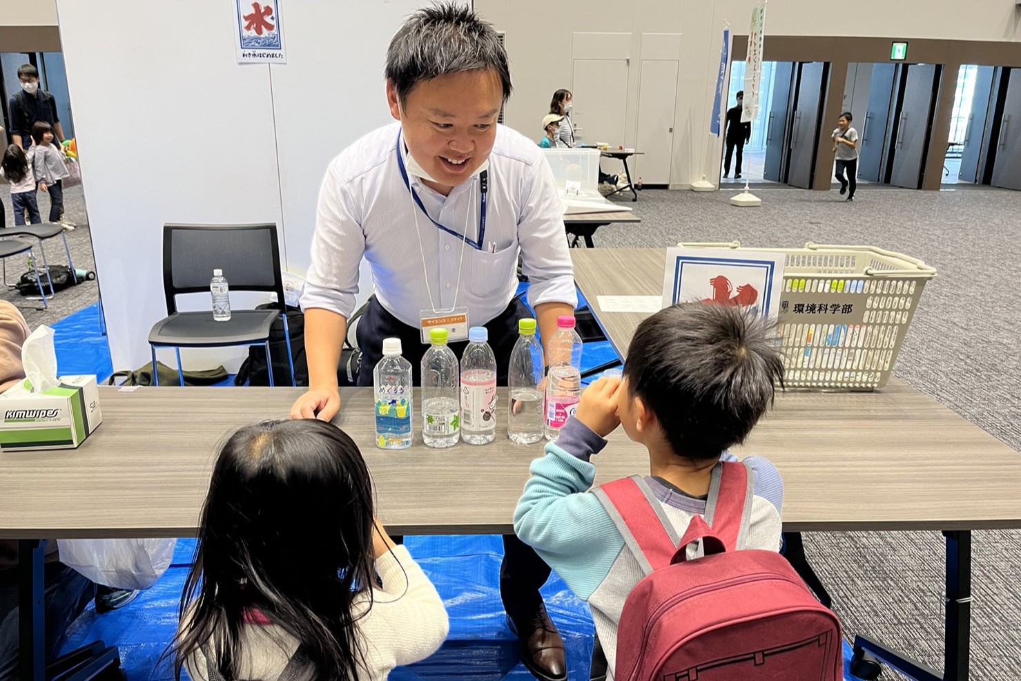 水研究の楽しさを小さい子供たちにも教えています。この写真はミネラルウォーターの味の違いについて、利き水を通じて体感してもらっている様子です。水の味の違いから、地域ごとの水質特性の違いという話に展開します。