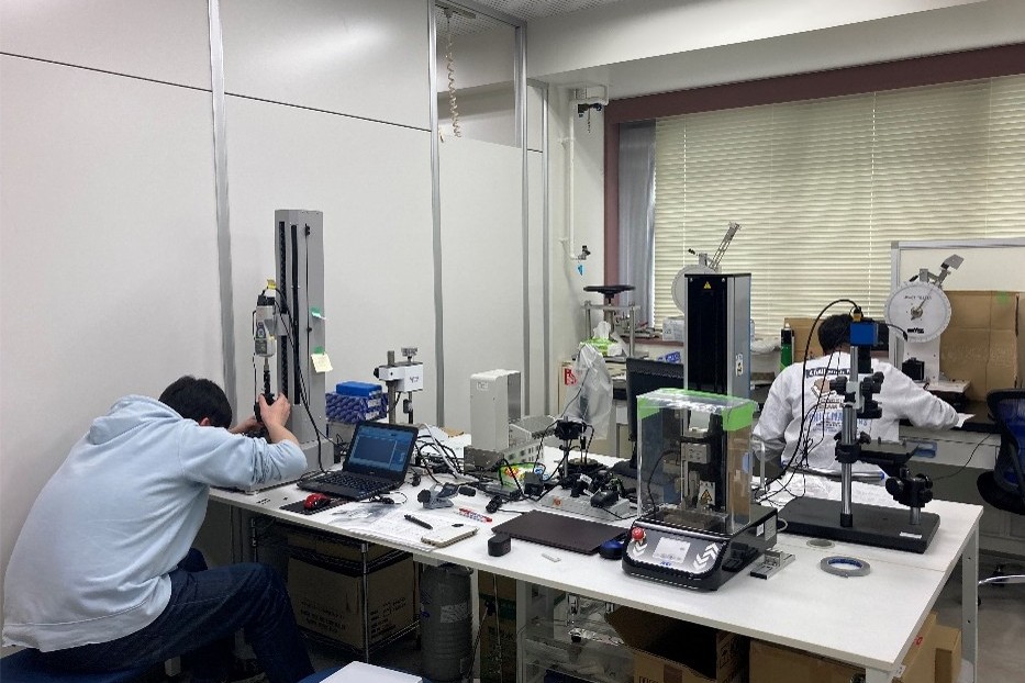 日ごろの研究室の風景。学生が実験している様子です。試験片が小さいので小さな装置で実験できます。