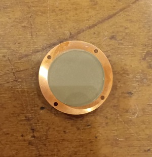 焦電性結晶を銅電極に接着したもので、装置の心臓部です。加熱・冷却すると厚さ5 mmの表面と裏面の間に約7万ボルトの電圧が生じます。