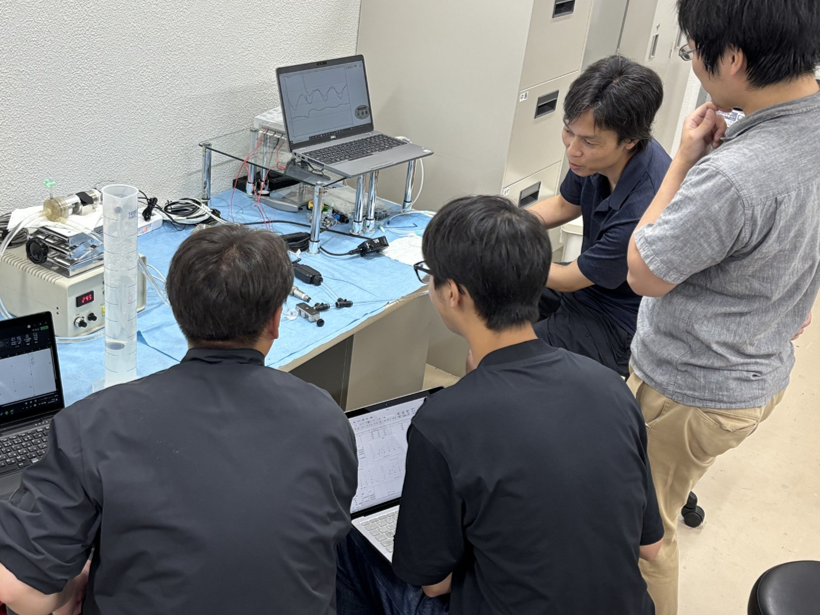 研究室の学生（左2人）と医師（右2人）が一緒に実験する様子