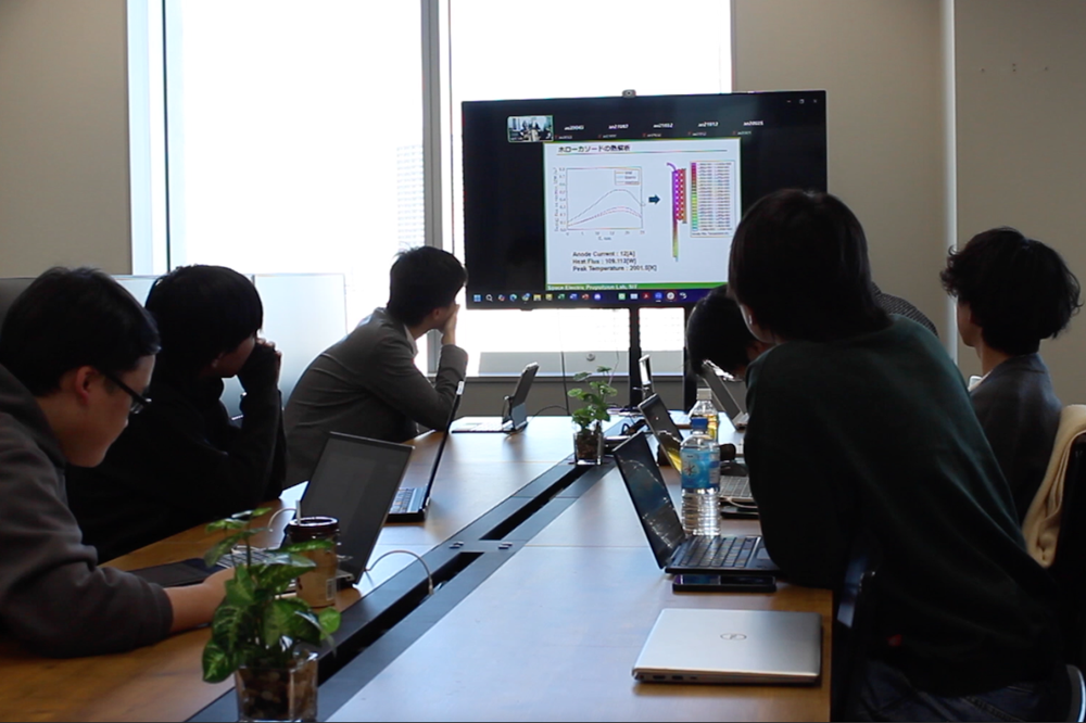 研究内容について議論する様子。研究室にはミーティングテーブルが設置されていて活発な議論が行われます。