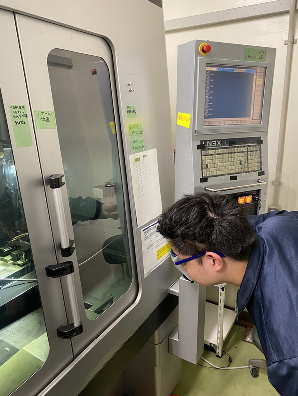 ものづくりに特化した機械（マシニングセンタ）を使った実験も行っています。大学の研究室で大学院生の学生が金属を削る実験を行っているところです。