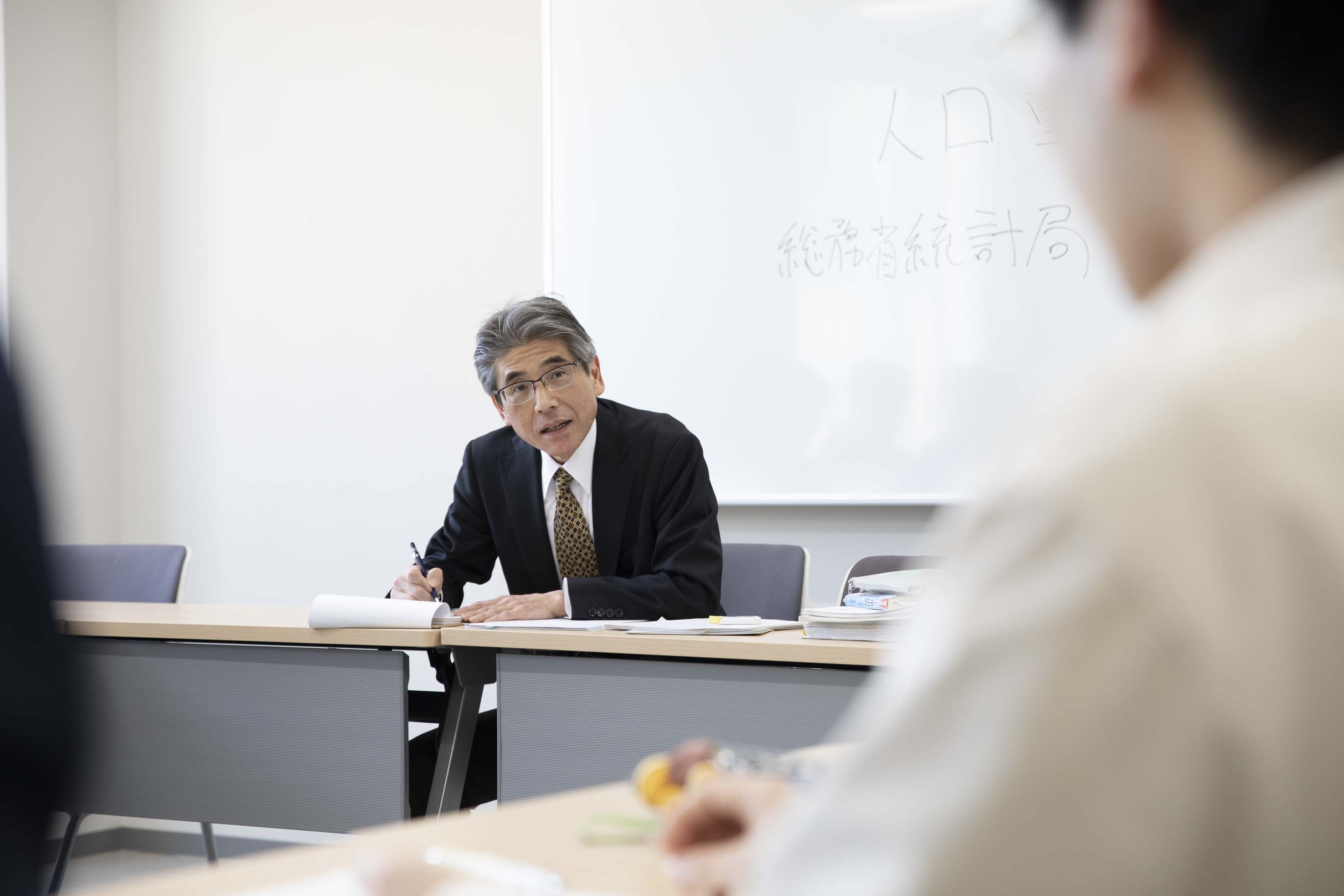 ゼミでの授業風景。学生に質問を投げかけ、問答方式で財政と社会保障の関係を解き明かしています。