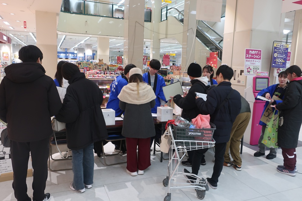 学生たちがショッピングモールでマーケティングの実験中