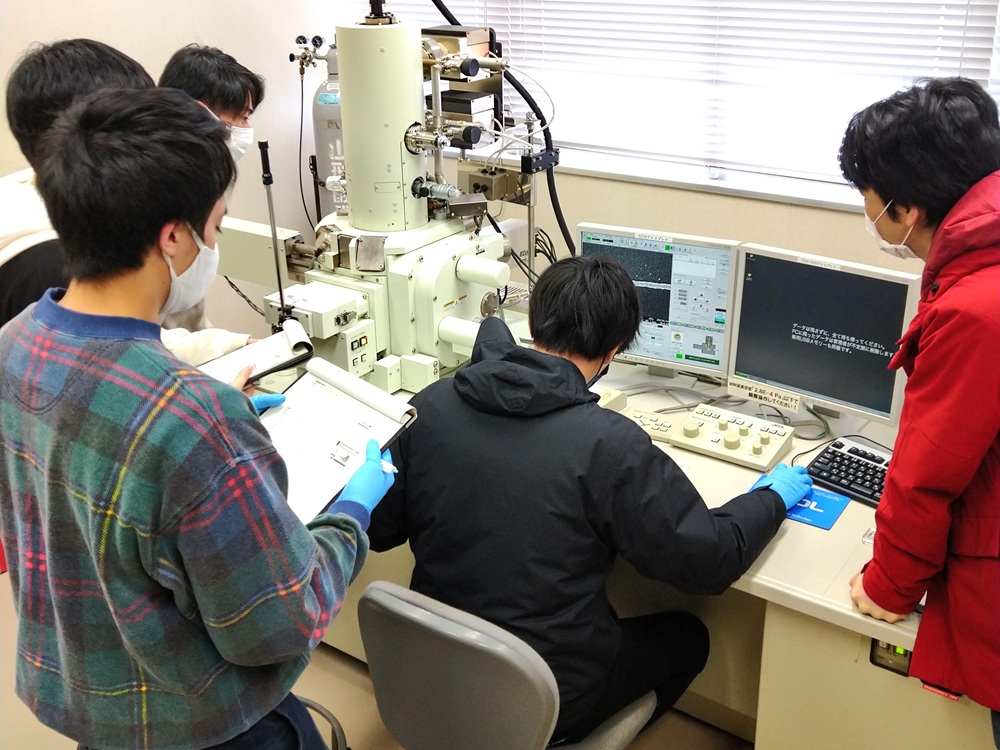 レーザー加工サンプルを高分解能な走査型電子顕微鏡で観察している学生たち