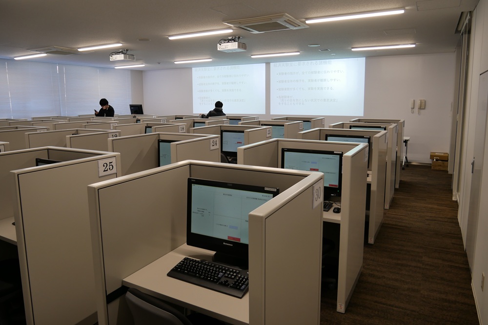 高知工科大学の経済実験室です。私の研究では、写真にある多数のパソコンをネットワークで接続し、仮想的な株式市場をつくって、参加者に取引してもらっています。