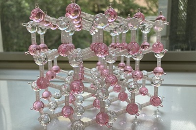 結晶の模型です。これは二種類の元素からなる化合物半導体のモデルです。半導体の結晶は理想的には規則正しく並んでいます。半導体の中に欠陥が生じてしまう場合や、半導体の表面がどのようになっているかを考えるときに、このような結晶構造モデルが理解の助けになります。