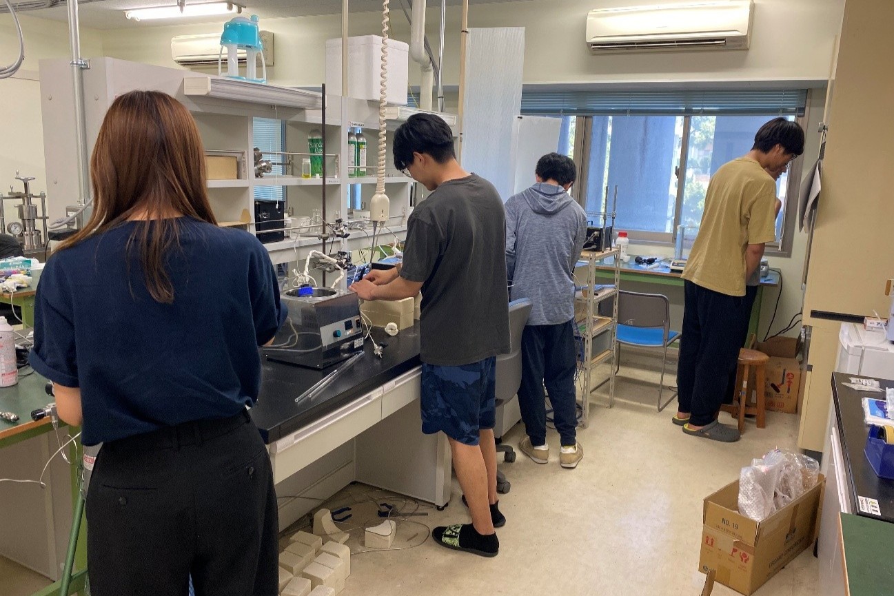 研究室の学生が協力して実験をしている様子。赤外線イメージランプで得られた高温集熱を熱源として、熱化学サイクル（二段階水熱分解反応）により水素製造の実験を行っています。