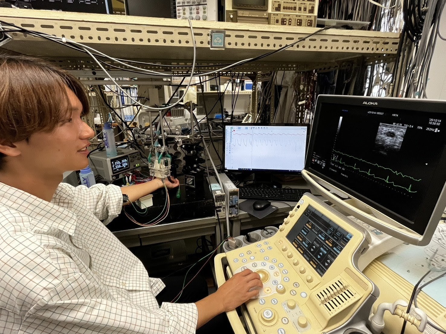 学生が血管壁の硬さと粘り気を測定している様子