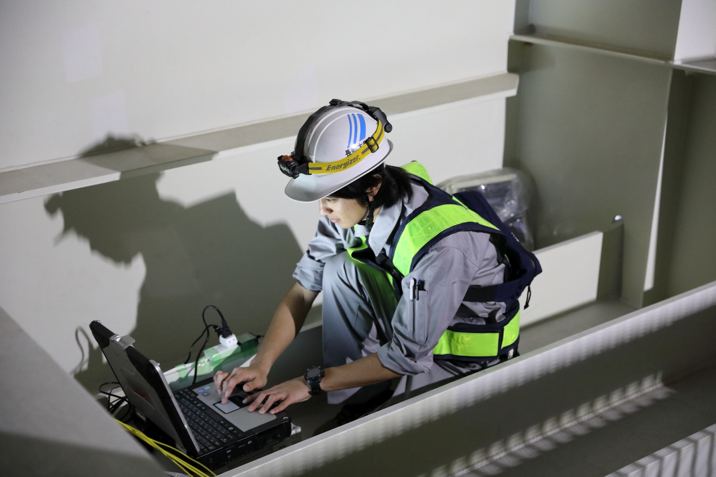 普段立ち入ることができない場所で研究を行うことも。写真は、橋桁の中で橋梁モニタリング研究に取り組む大学院生