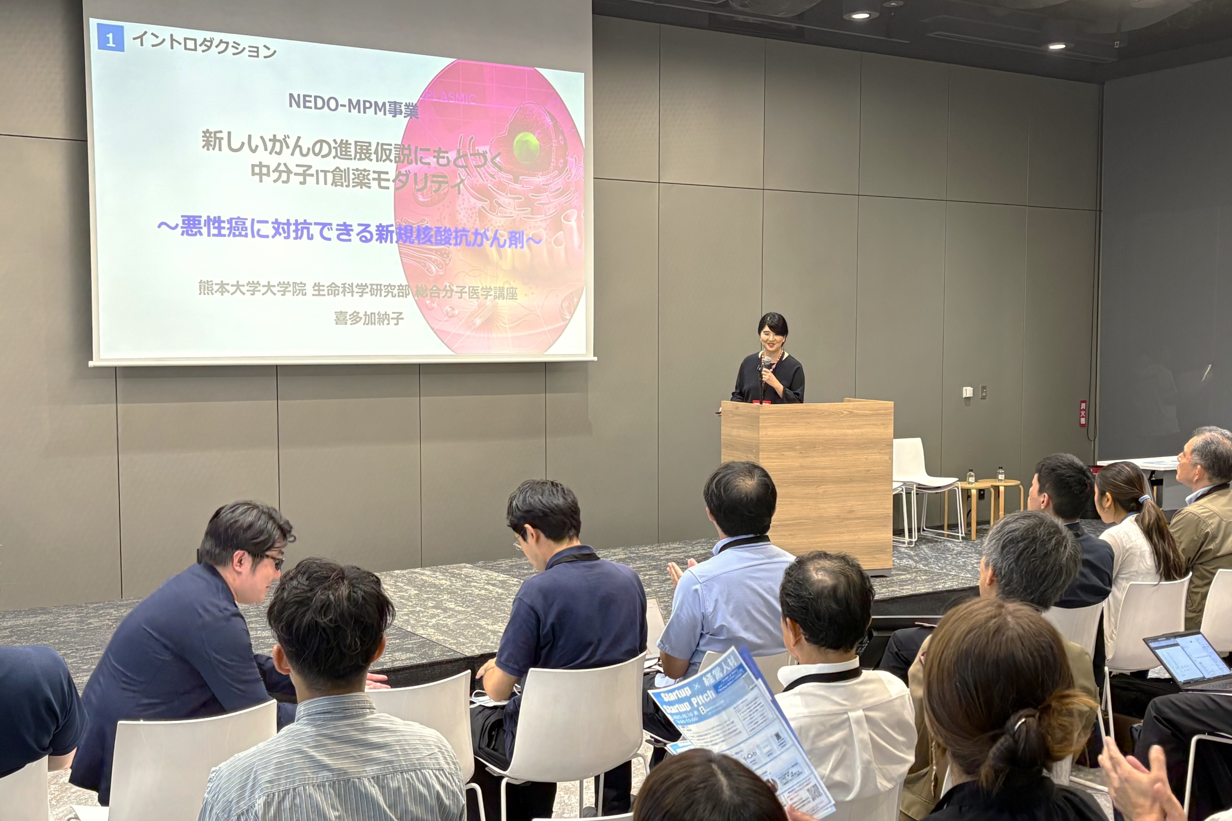 ディープテック・スタートアップ（DTSU）を支援するイベント（NEDO-MPM事業）で研究発表する様子。DTSUとは、最先端の科学技術・研究成果の事業化を担う重要なプレイヤーのことです。私たちのチームは、がん治療用核酸医薬の社会実装に挑戦すべく、熊本大学発スタートアップの設立を目指しております。