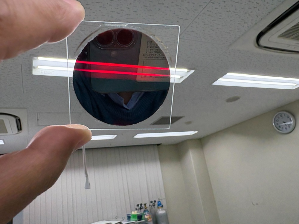 自身のベンチャー企業との共同で作製した化合物半導体薄膜です。半導体の性質によって、青や緑の光は吸収し、赤い光が透過して見えます。このように光を吸収する性質は、太陽電池の性能にとってとても重要です。