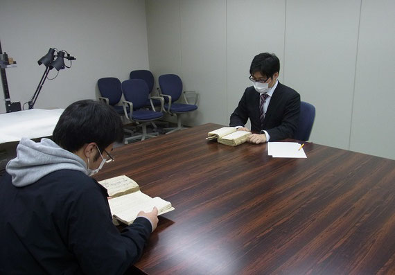 秋田県公文書館にて、学生と公文書の調査をしている様子