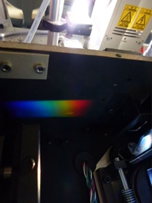 分光器(キセノンランプ)。太陽に似た白色光を出すキセノンランプからの光を分光器（回折格子）に通しました。きれいな虹色が見え、白色光は様々な波長の光が集まったものであるということが確認できます。