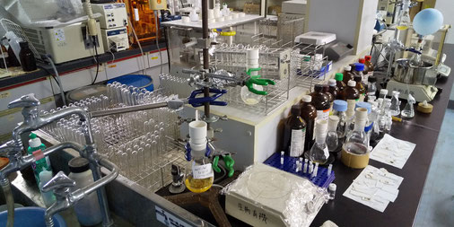 研究室の風景：実験室は化学実験に使う機器類とガラス器具であふれています。写真は私の実験台、午前中の様子です。午後には片付いています（笑）