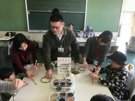 千葉市内の公民館において、園芸療法プログラムを実践しています。中央に岩崎、その両脇に研究室の学生2名が、子供や高齢者を相手に園芸プログラムを教えています。このときは色々な豆をつかったリースを作りました。